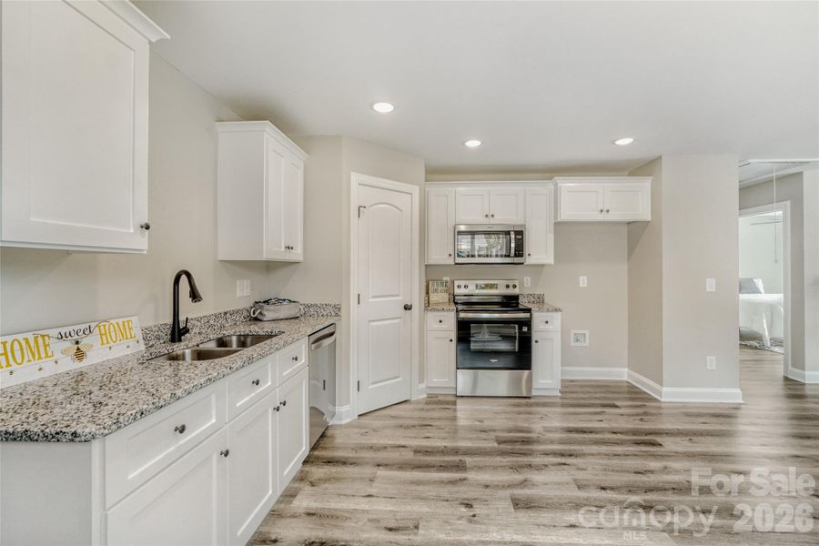Granite countertops, modern white cabinetry and stainless steel appliances Granite countertops, modern white cabinetry and stainless steel appliances