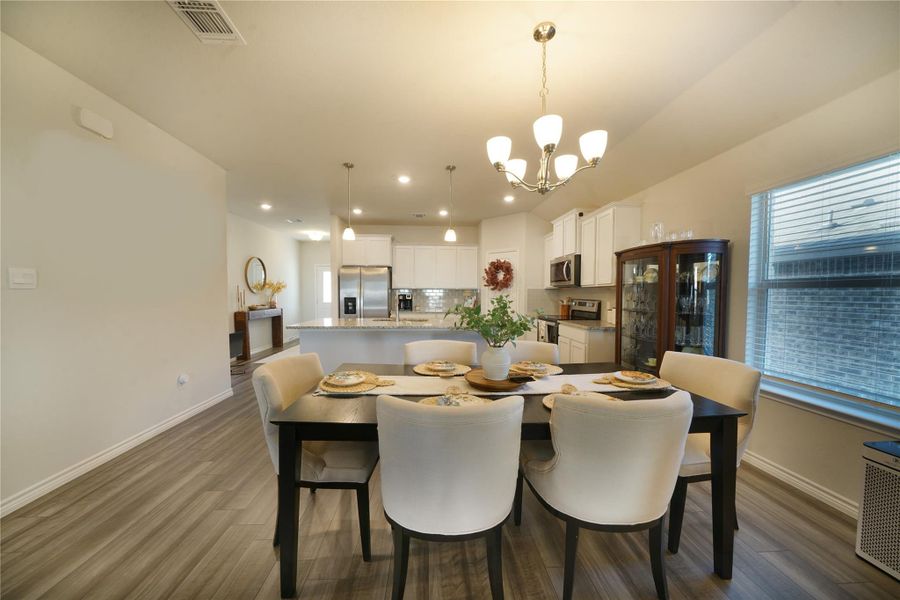 Dining room featuring dark wood-type flooring, a chandelier, and recessed lighting