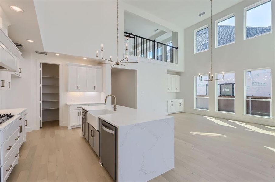 Kitchen featuring sink, dishwasher, plenty of natural light, and an island with sink