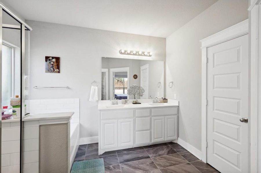 Bathroom featuring separate shower and tub and vanity