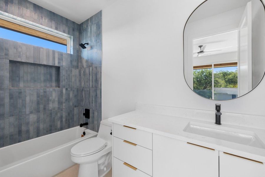 Bathroom featuring plenty of natural light, shower / tub combination, vanity, and a ceiling fan Bathroom featuring plenty of natural light, shower / tub combination, vanity, and a ceiling fan