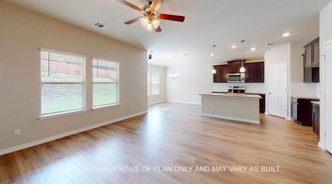Kitchen featuring appliances with stainless steel finishes, a ceiling fan, open floor plan, baseboards, and light wood-type flooring Kitchen featuring appliances with stainless steel finishes, a ceiling fan, open floor plan, baseboards, and light wood-type flooring