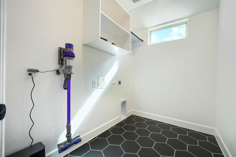 Washroom with electric dryer hookup and tile patterned flooring