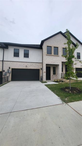 View of front facade featuring concrete driveway, stucco siding, and a garage
