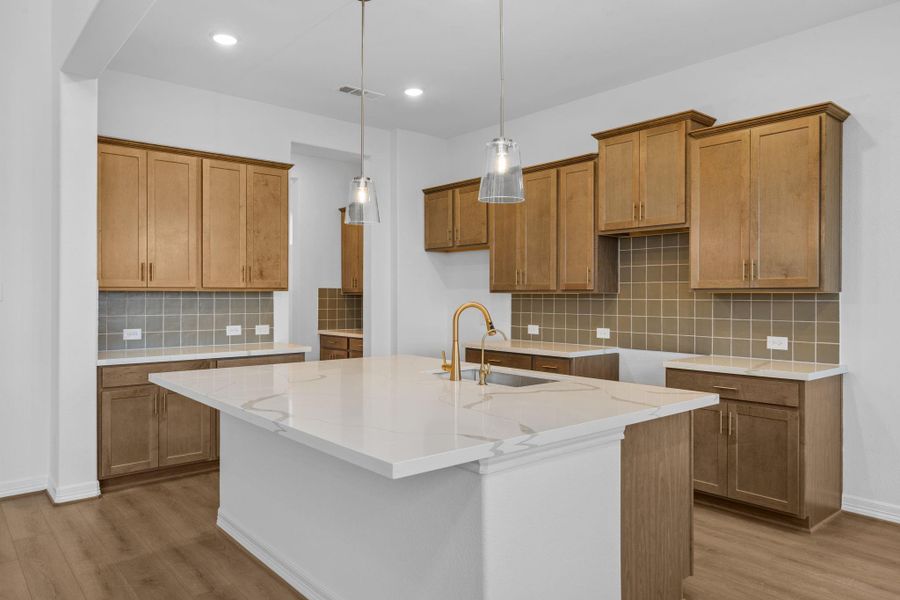 A chef’s dream kitchen with a central island, spacious walk-in pantry, and open connection to the living area.