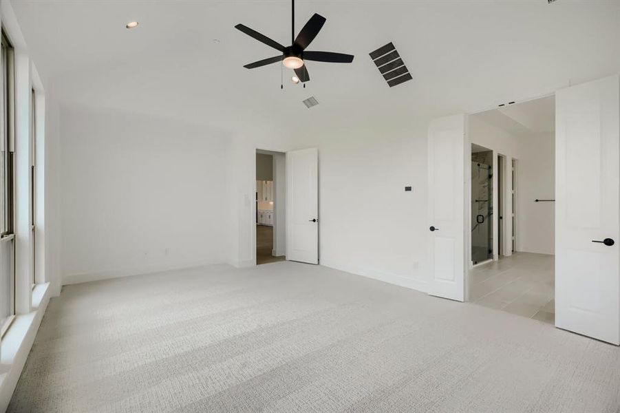 Unfurnished bedroom featuring light colored carpet, a ceiling fan, lofted ceiling, and recessed lighting