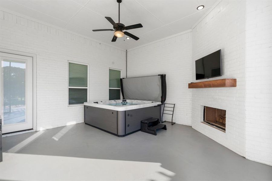 Home office with brick wall, ceiling fan, and concrete flooring