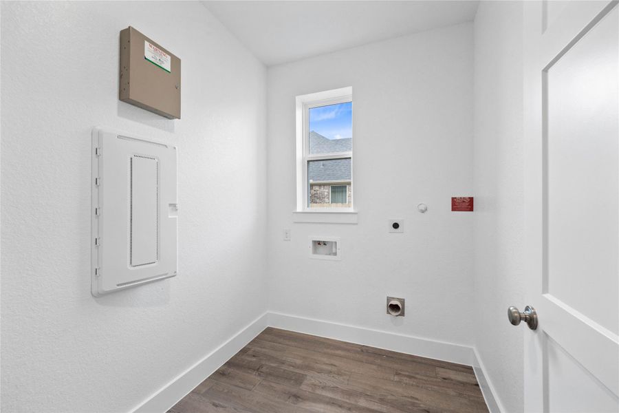 This bright and functional laundry room is conveniently located and ready for your appliances. It features clean white walls and trim, and a large window providing abundant natural light.