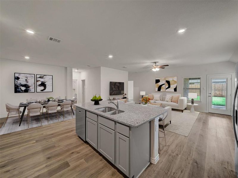 Kitchen with a sink, visible vents, stainless steel dishwasher, gray cabinetry, and open floor plan