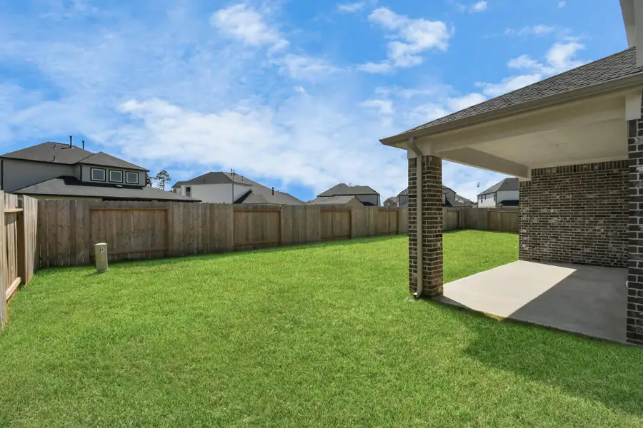 Experience outdoor living at its finest on this expansive covered patio, thoughtfully designed for BBQs and delightful outdoor dining. Sample photo of completed home with similar floor plan. Actual colors and selections may vary.