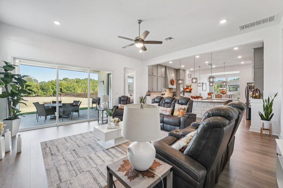 Expansive sliding glass doors frame views of the lush backyard and open to the covered patio for indoor-outdoor living.