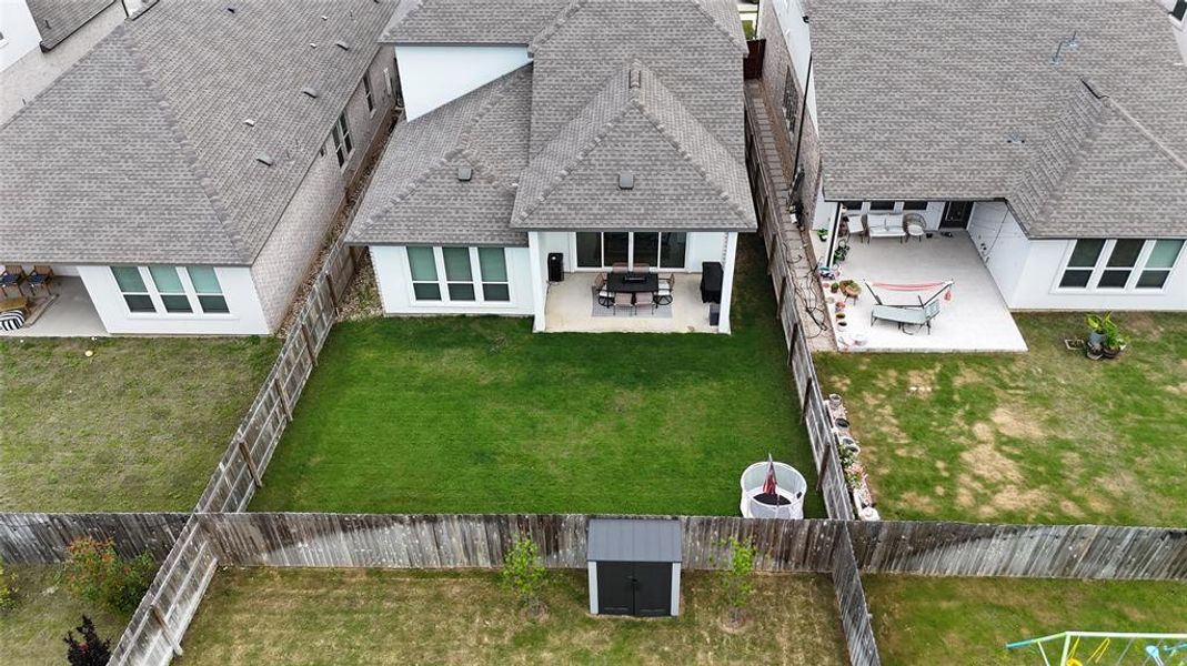 A fenced backyard offers a paved patio ideal for al fresco dining and a dedicated storage shed. A fenced backyard offers a paved patio ideal for al fresco dining and a dedicated storage shed.