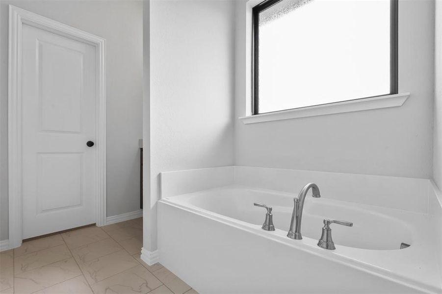 Bathroom featuring tile patterned flooring and a bathing tub