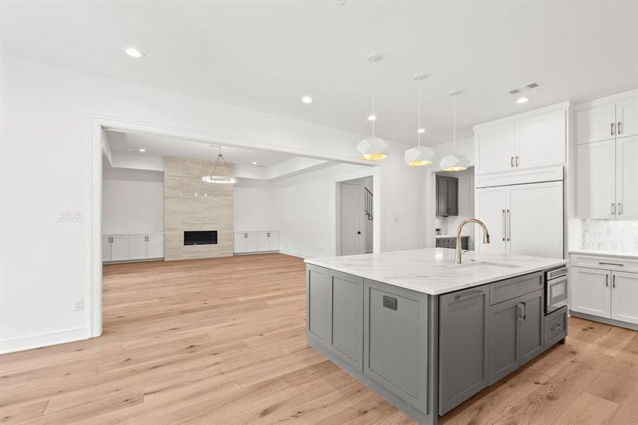 Kitchen with gray cabinets, white cabinets, hanging light fixtures, light wood-type flooring, and recessed lighting Kitchen with gray cabinets, white cabinets, hanging light fixtures, light wood-type flooring, and recessed lighting
