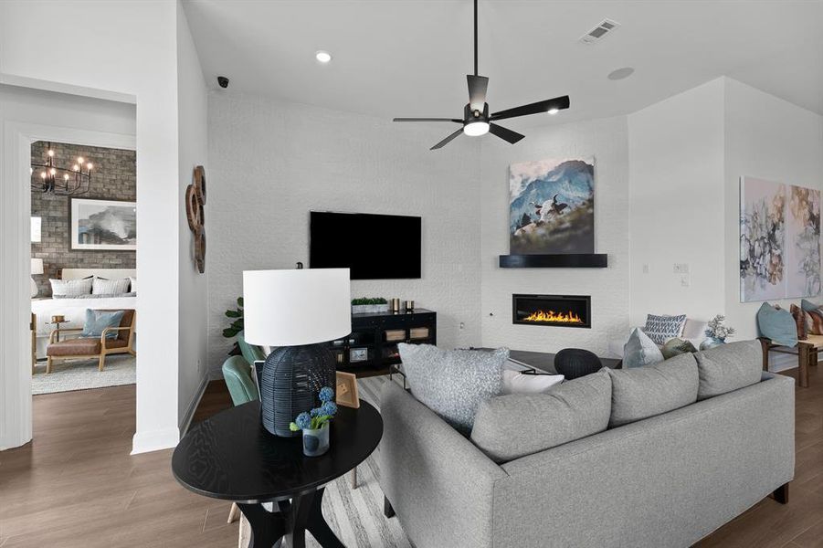 Living room featuring a fireplace, a ceiling fan, wood finished floors, and recessed lighting Living room featuring a fireplace, a ceiling fan, wood finished floors, and recessed lighting