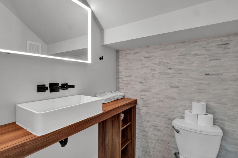 Bathroom featuring toilet and vaulted ceiling