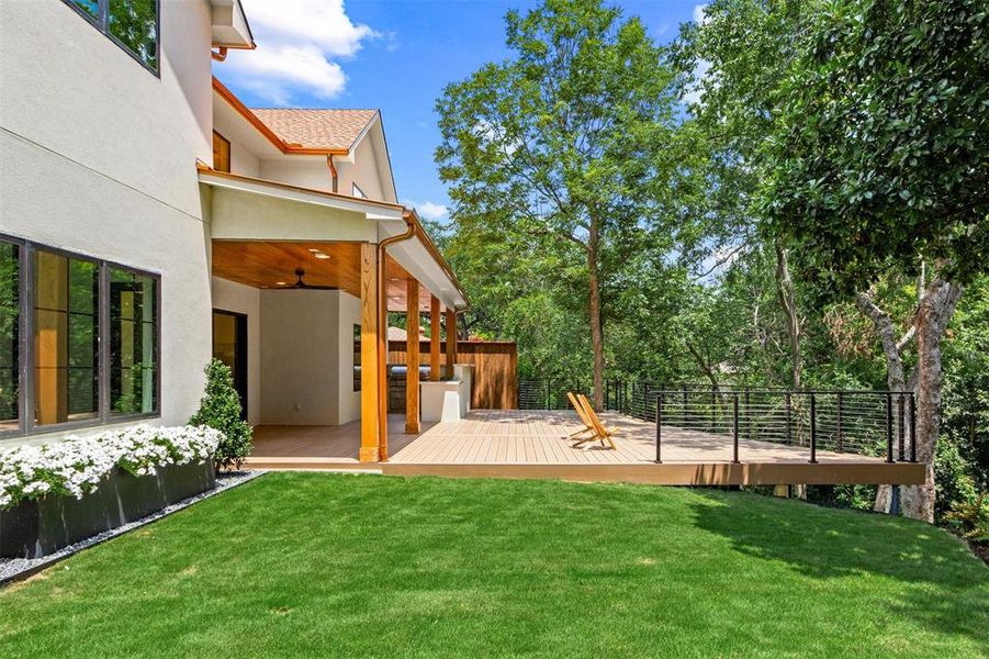 View of grassy yard featuring a wooden deck