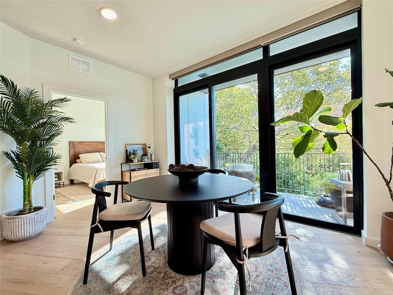 Natural light floods this inviting eating area, opening to an outdoor balcony.