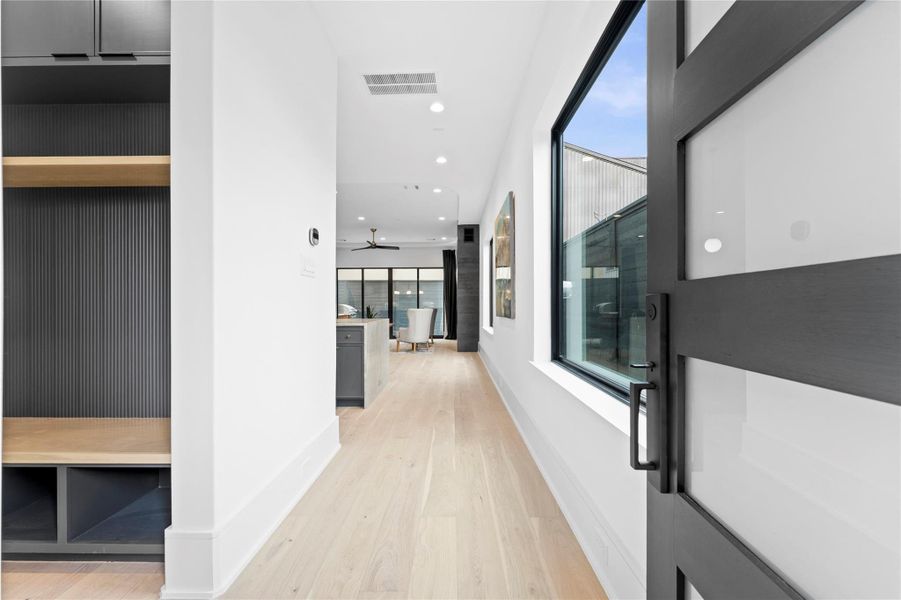 Light-filled entry with wide plank flooring and modern accents. each floor has their own security alarm controller.