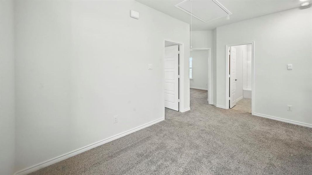 Empty room featuring attic access and carpet