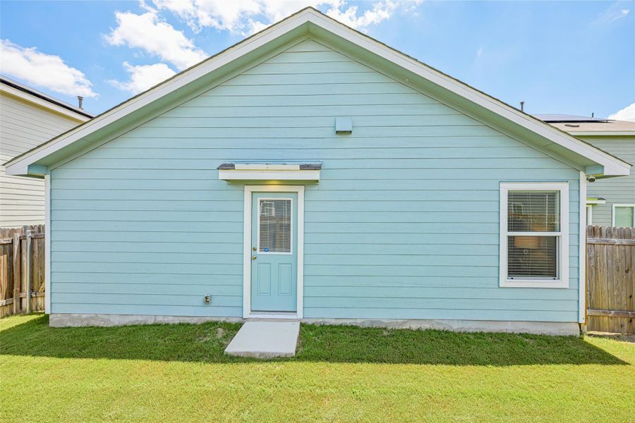 Light blue horizontal siding exterior featuring a white-trimmed door with a glass insert, a white-trimmed window, a small awning, and a concrete ramp leading to the door Light blue horizontal siding exterior featuring a white-trimmed door with a glass insert, a white-trimmed window, a small awning, and a concrete ramp leading to the door