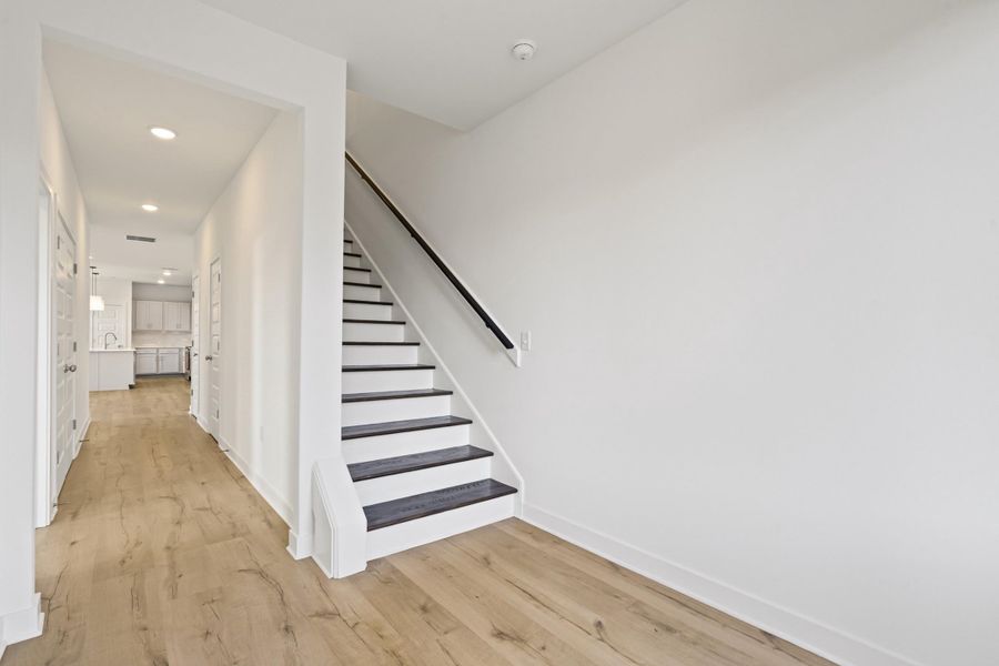 Stairway featuring wood finished floors and recessed lighting
