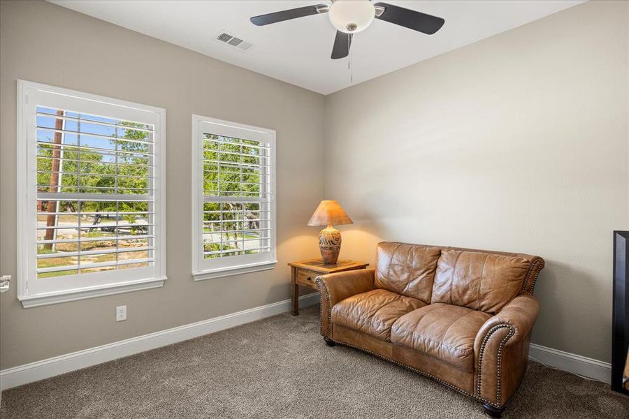 Sitting room with carpet flooring and a ceiling fan Sitting room with carpet flooring and a ceiling fan