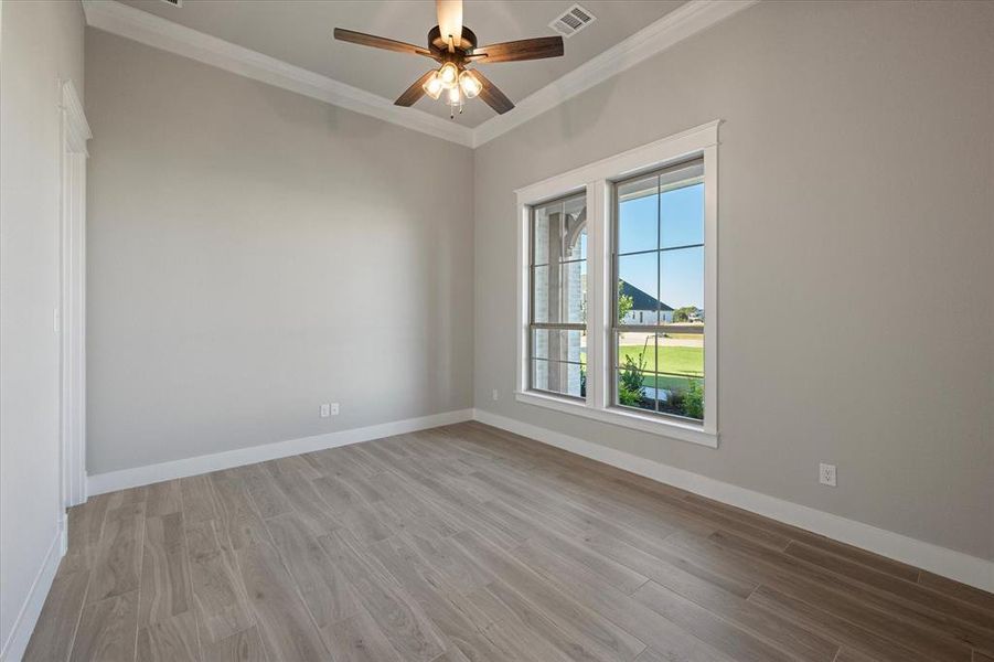 Office with walk-in closet, ceiling fan, and crown molding