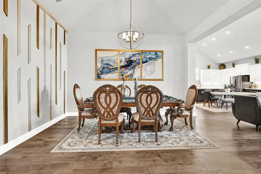 Dining area featuring vaulted ceiling, recessed lighting, light wood-style flooring, and a chandelier Dining area featuring vaulted ceiling, recessed lighting, light wood-style flooring, and a chandelier