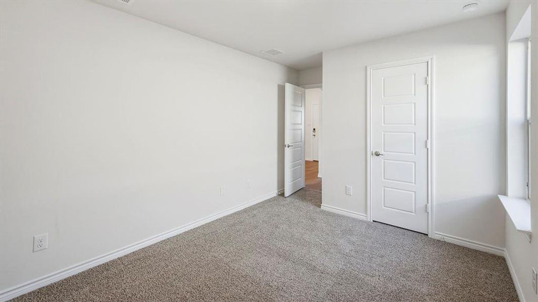 Unfurnished bedroom with carpet flooring and baseboards Unfurnished bedroom with carpet flooring and baseboards