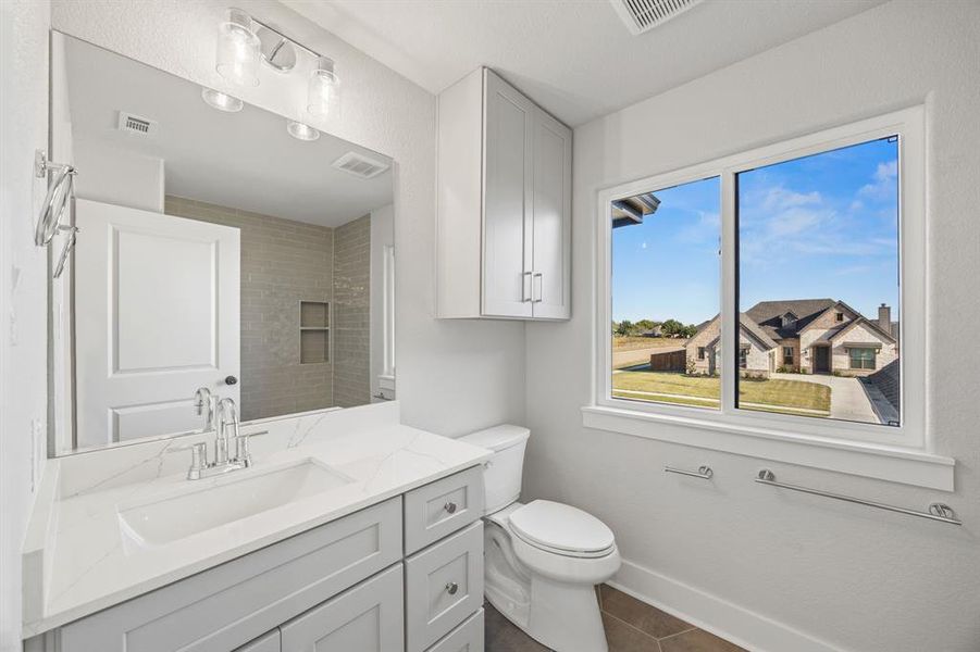 Bathroom featuring vanity, dark tile patterned floors, and a shower