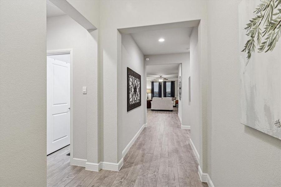Hallway with wood finished floors, and recessed lighting Hallway with wood finished floors, and recessed lighting