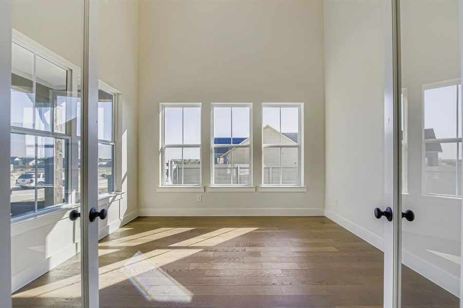 Spacious study with double glass doors and soaring ceilings