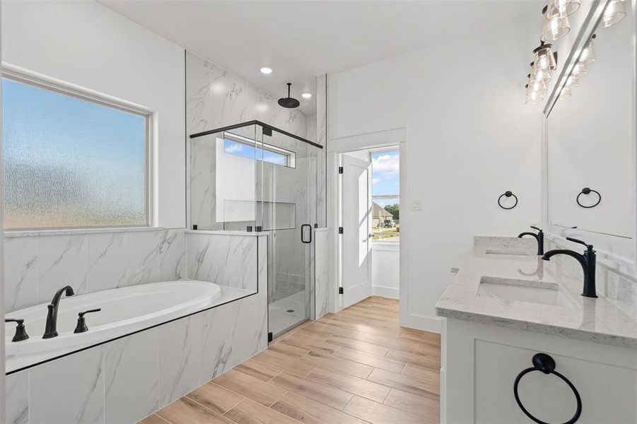 Bathroom with a garden tub, a marble finish shower, healthy amount of natural light, wood finish floors, and recessed lighting