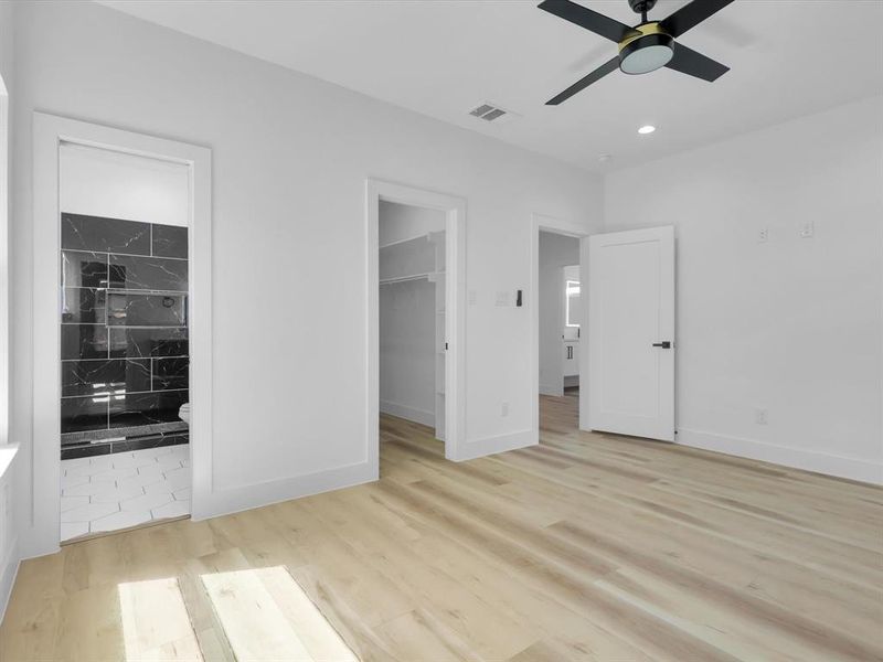 Unfurnished bedroom featuring a spacious closet, a closet, ceiling fan, and light tile patterned floors