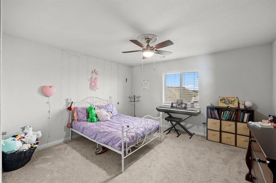 Bedroom with light carpet and a ceiling fan Bedroom with light carpet and a ceiling fan