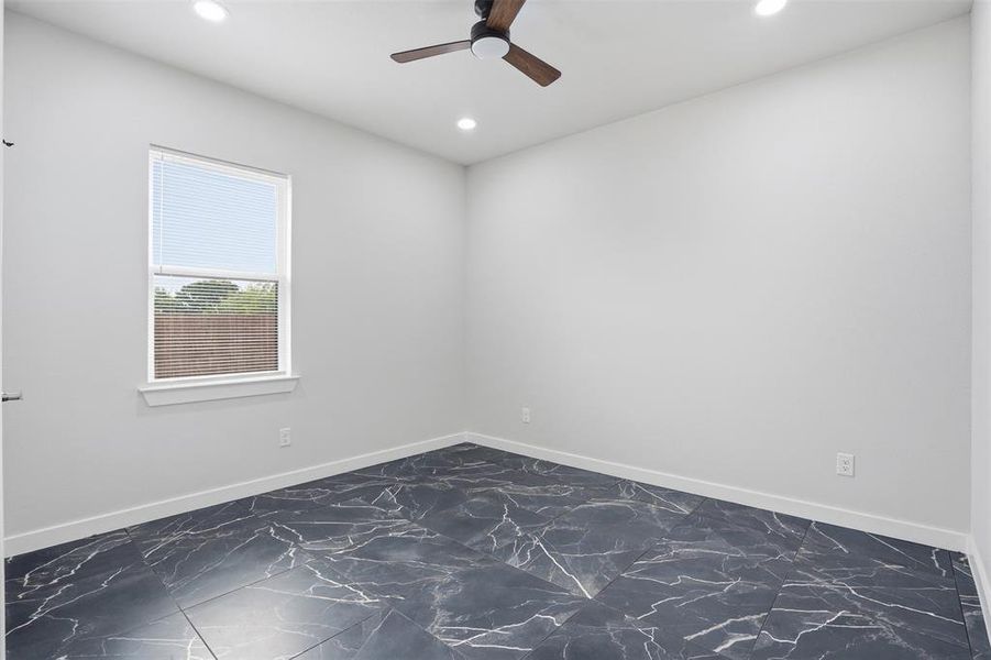 Room featuring dark tile flooring with white veining, a white window frame, and recessed lighting
