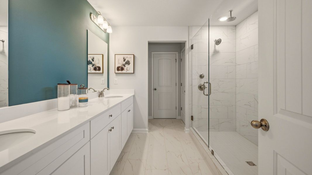 Primary bathroom with dual vanity and spacious glass enclosed shower with shower window Primary bathroom with dual vanity and spacious glass enclosed shower with shower window
