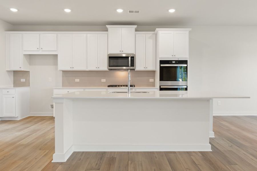 A kitchen with white cabinets.