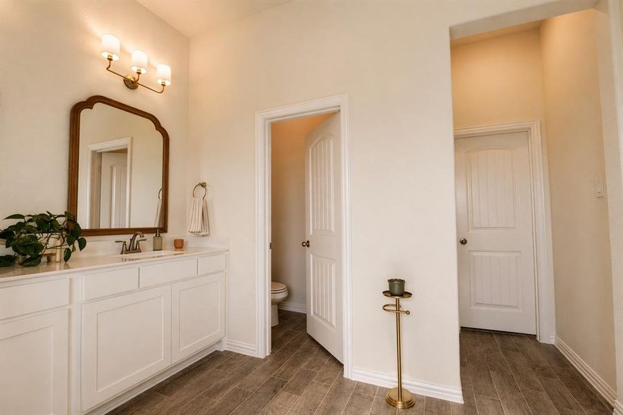Bathroom vanity featuring a white countertop, under-mount sink, and brushed nickel faucet