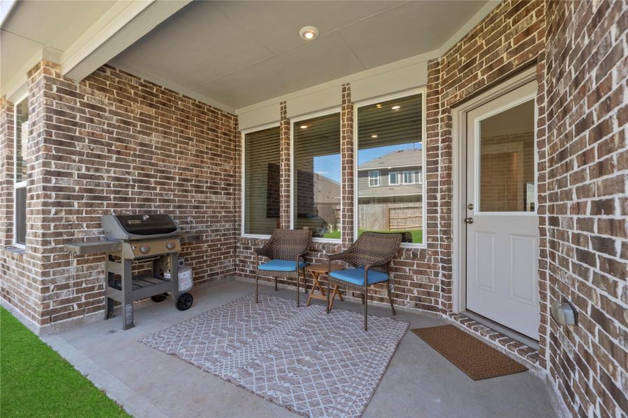 Covered back patio perfect for relaxing or entertaining, with space for seating and outdoor dining year-round.