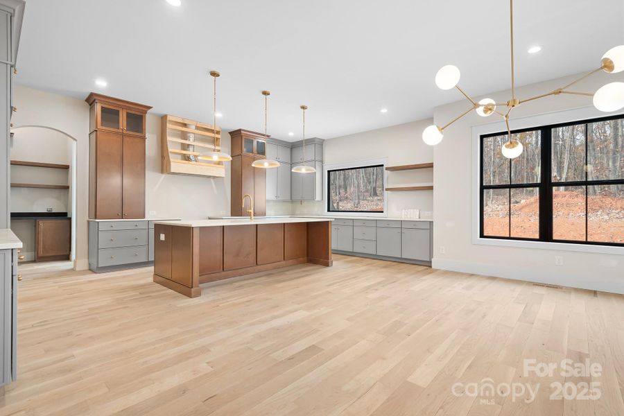A chef-inspired kitchen with two-toned cabinetry, high end finishes & an open layout. The range hood will be trimed out with a wood stained trim piece tying it all together.