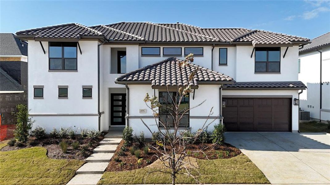 Mediterranean / spanish-style house with a garage and central air condition unit