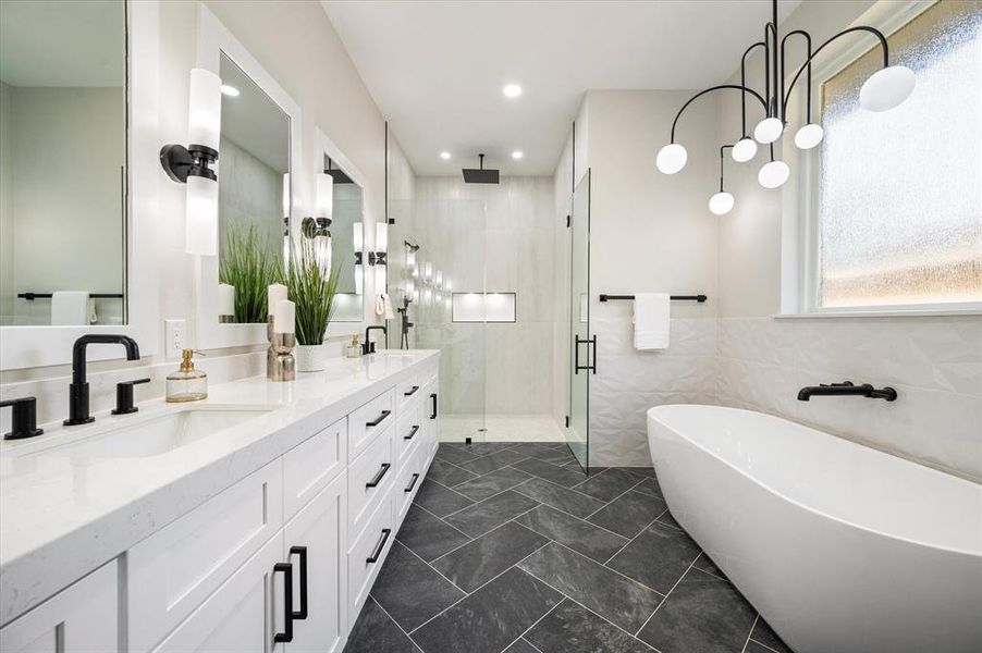 Bathroom featuring tile walls, independent shower and bath, and vanity