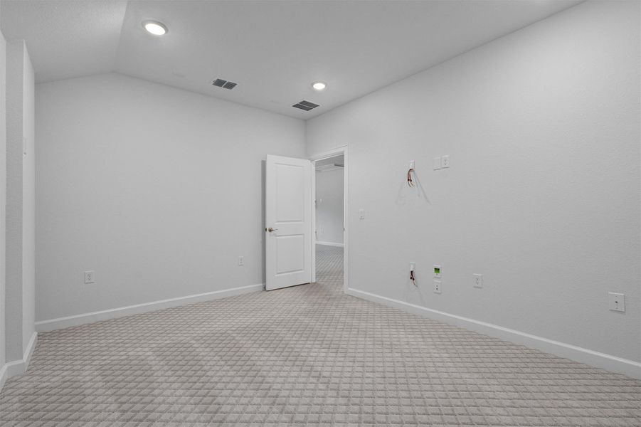 Empty room with light carpet, lofted ceiling, and recessed lighting Empty room with light carpet, lofted ceiling, and recessed lighting
