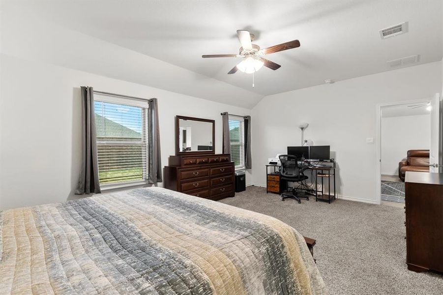 Bedroom featuring light carpet, an office area, ceiling fan, and lofted ceiling