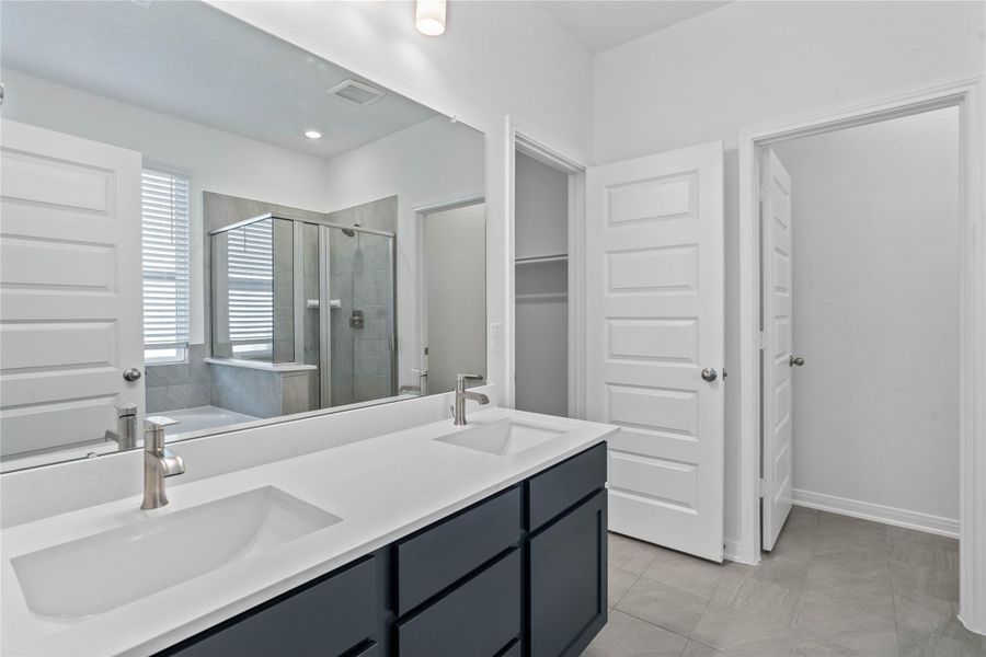 This primary bathroom is definitely move-in ready! Featuring stained cabinets with light countertops, dual vanities, high ceilings, neutral paint, walk-in closet, sleek and modern finishes.