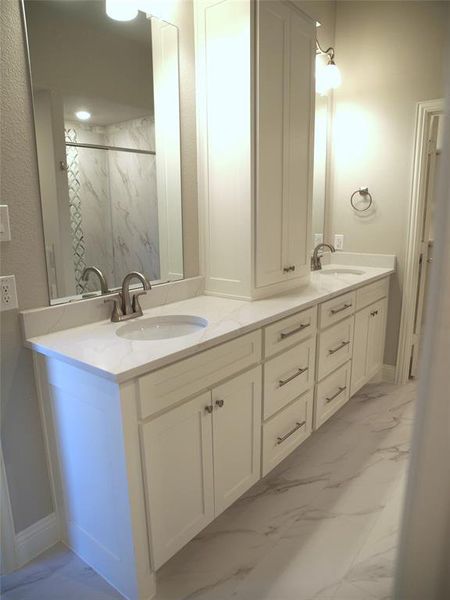 Bathroom featuring a tile shower and vanity