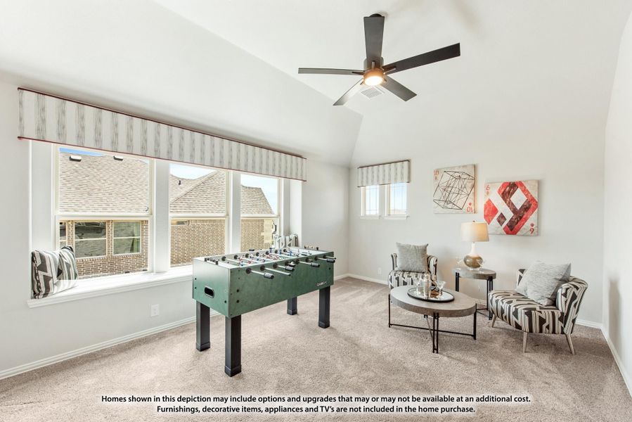 Game room with foosball table, vaulted ceiling, ceiling fan, and seating area on carpet