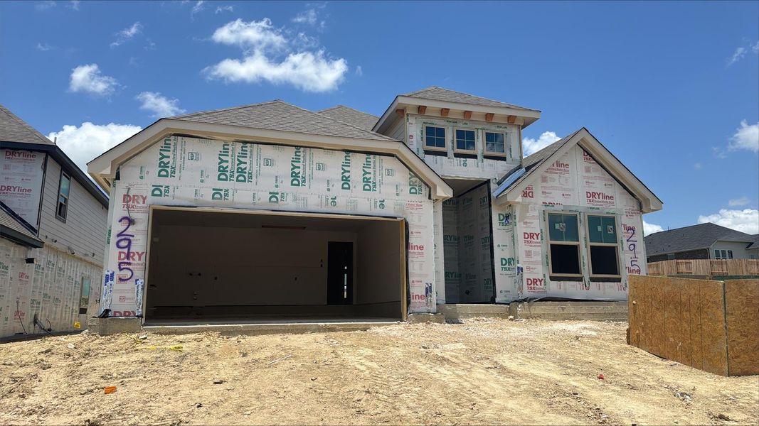 Unfinished property featuring driveway, an attached garage, and a shingled roof Unfinished property featuring driveway, an attached garage, and a shingled roof